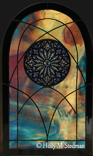 Arch-shaped stained glass panel with an inner intricate circular design