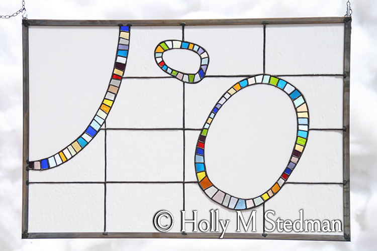 Stained glass panel of ovals with brightly colored borders