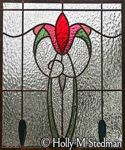 Geometric stained glass panel of red flower with textured glass