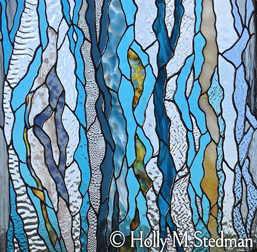 Close up of stained glass window with a flowing blue pattern