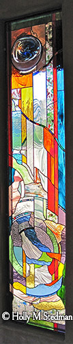 Long stained glass window with flowing and colorful abstract pattern