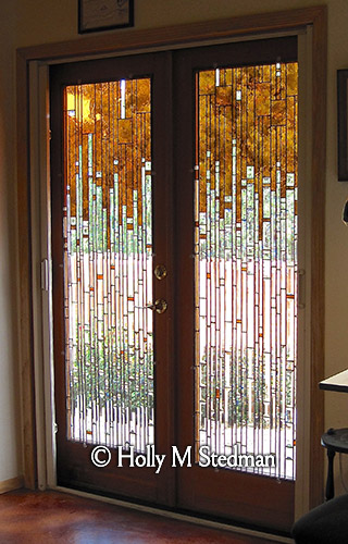 Stained glass door with orange and transparent geometric design