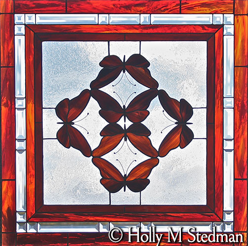 Stained glass panel of red butterflies