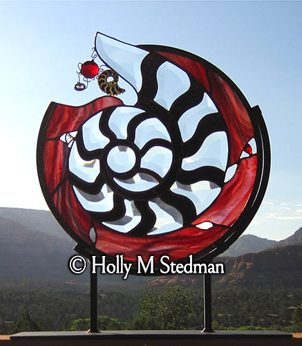 Stained glass sculpture of nautilus shell with red background
