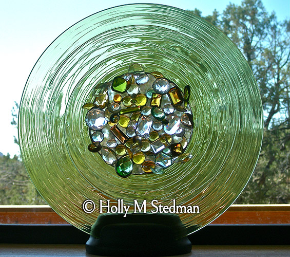 Circular stained glass sculpture with glass pieces in the center