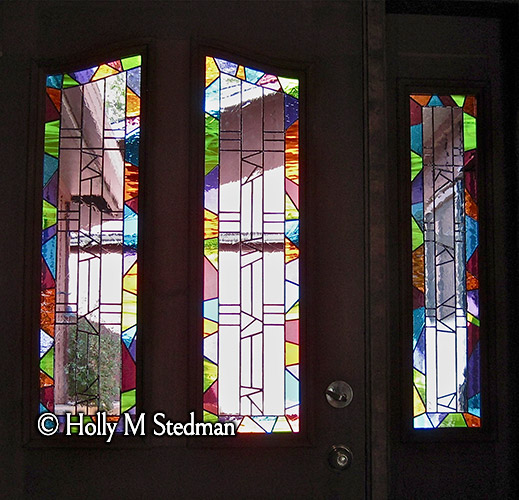 Three stained glass windows with matching designs